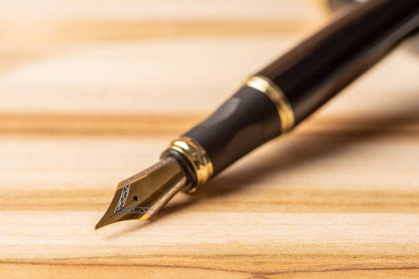 istock Fountain pen, beautiful fountain pen positioned on a rustic wooden surface, selective focus. 1362887633