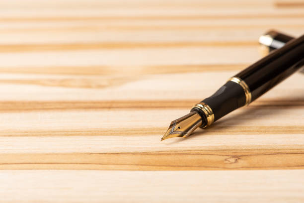 istock Fountain pen, beautiful fountain pen positioned on a rustic wooden surface, selective focus. 1362887637