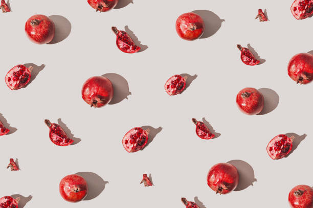 istock Creative pattern made of fresh pomegranates on pastel grey background with sunlit. Minimal style. Top view. Flat lay . 1362888605
