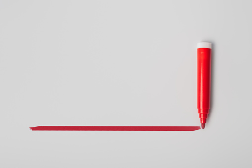 Red highlighter pen and a hand drawn red line, isolated on gray background, template with space for text
