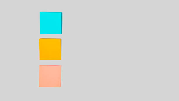 istock Three blank colorful sticky notes on gray background for entering a text. Top view and space for text. Still life, business, office supplies or education concept 1362889496