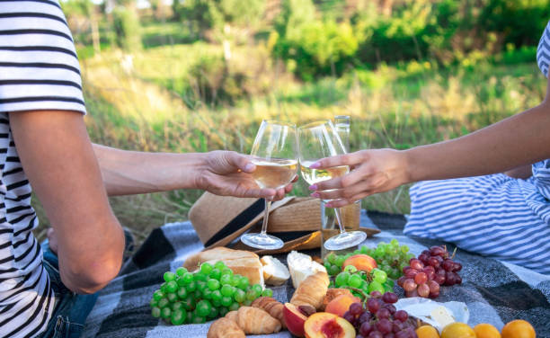 istock couple in love drinks wine at a picnic. Selective focus 1362890575