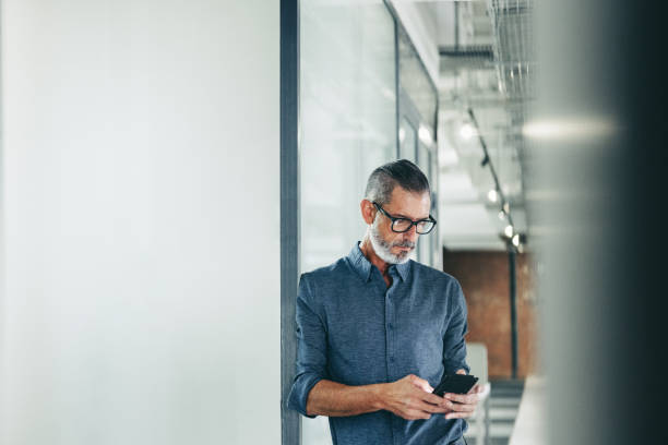 istock Experienced businessman using a smartphone in an office 1362892205