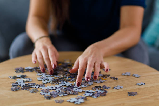 istock Young woman solving a jigsaw puzzle 1362893050