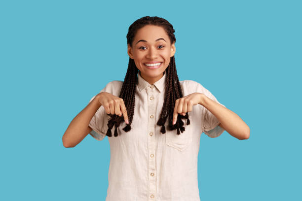 istock Woman pointing down, advertises new product, looking at camera with happy expression. 1362893461