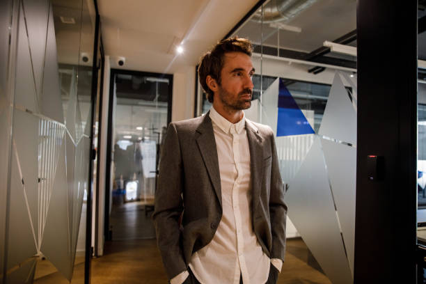 istock Businessman walking through the modern office space, hands in pockets 1362893655
