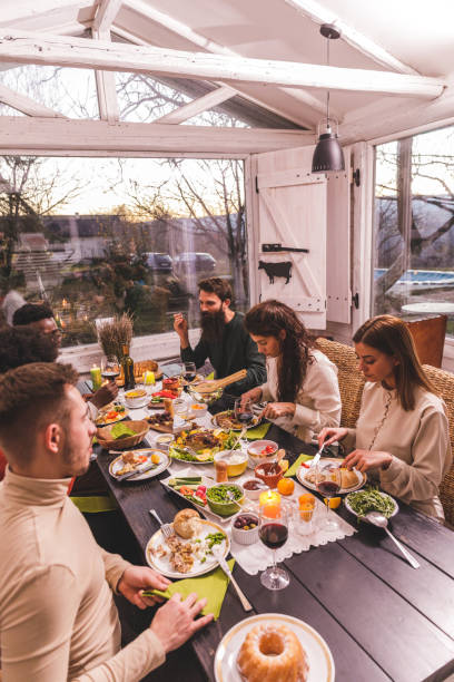 istock Group of friends sitting at dining table, enjoying a Thanksgiving dinner 1362894683