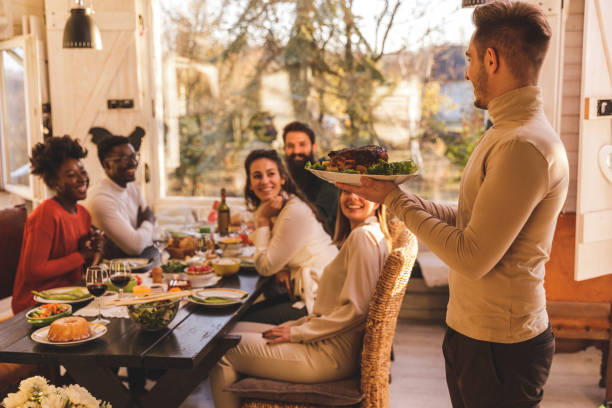 istock Young man serving roast chicken during a dinner with friends 1362894688