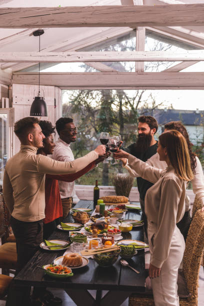 istock Diverse group of friends cheering with red wine before enjoying Thanksgiving dinner 1362894706