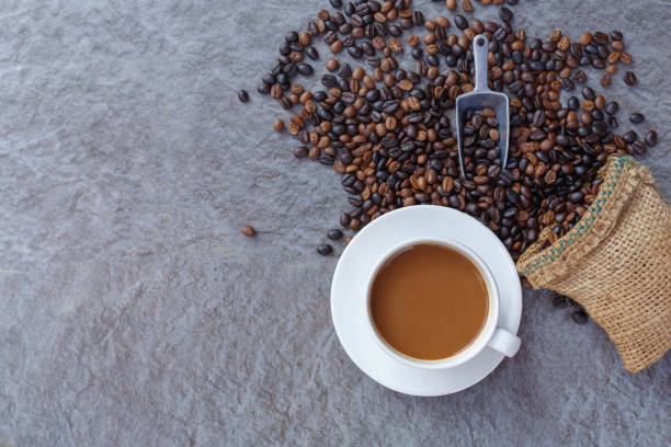 istock Coffee cup and roasted coffee beans in brown bag, top view. 1362895370
