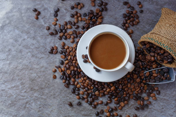 istock Coffee cup and roasted coffee beans in brown bag, top view. 1362895386