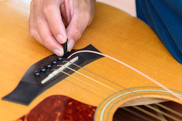istock The musician replace the new guitar strings for his guitar 1362895441