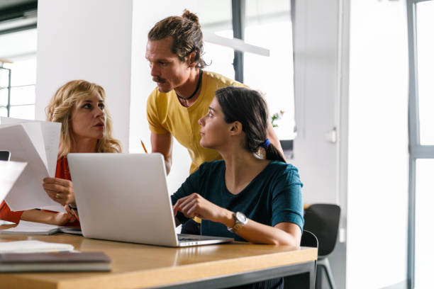 istock Hipster businessman reviewing data and documents with his female colleagues 1362896148