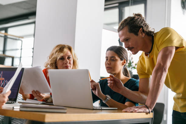 istock Business people reviewing data on laptop while co-working on a project 1362896154