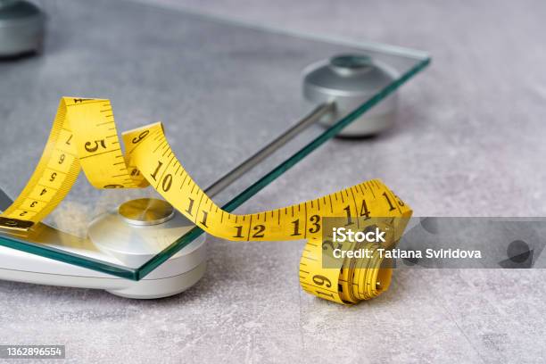 Yellow Tape Measure On Glass Bathroom Scale Stock Photo - Download Image Now - Weight Scale, Scale, Tape Measure