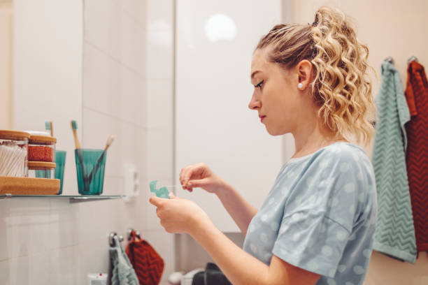 young woman at home - dental floss brushing teeth dental hygiene dental equipment imagens e fotografias de stock