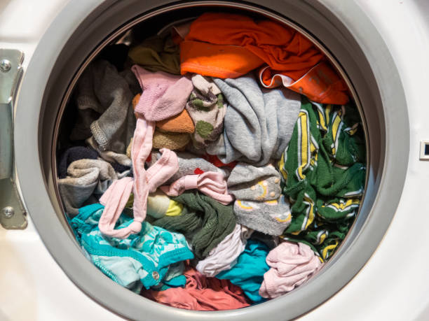 istock man puts clothes in the washing machine, close-up 1362904451