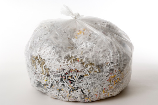 Shredded documents in garbage bag isolated on white background.