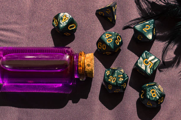 Close-up image of a set of rpg dice and a pink potion stock photo