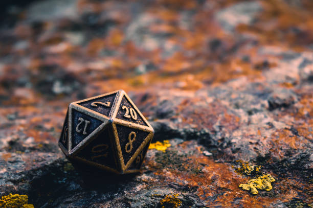 istock Close-up image of a metal d20 on a rocky surface covered with orange lichen 1362905821