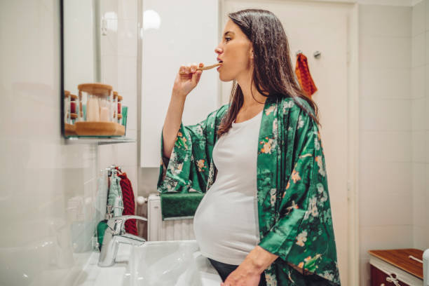 istock At home - young woman brushing her teeth 1362909473