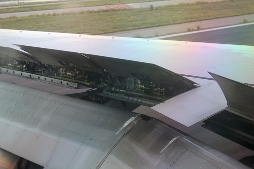 detail of the wing of an airplane with the flaps in motion during the\nlanding