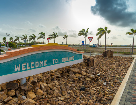 Welcome sign Bonaire and palmtrees, early morning.