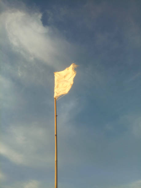 istock waving white flag against the blue sky background. 1362918812