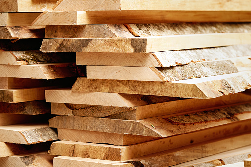 Lots of sawn but untreated wood planks in a pallet. At a furniture factory.