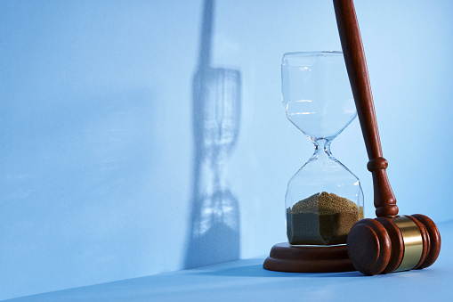hour glass and gavel hammer on the blue background