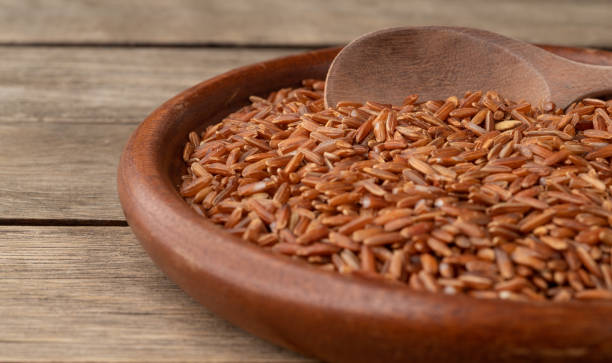 istock Narrow focus, raw red rice in a plate over wooden table 1362921390