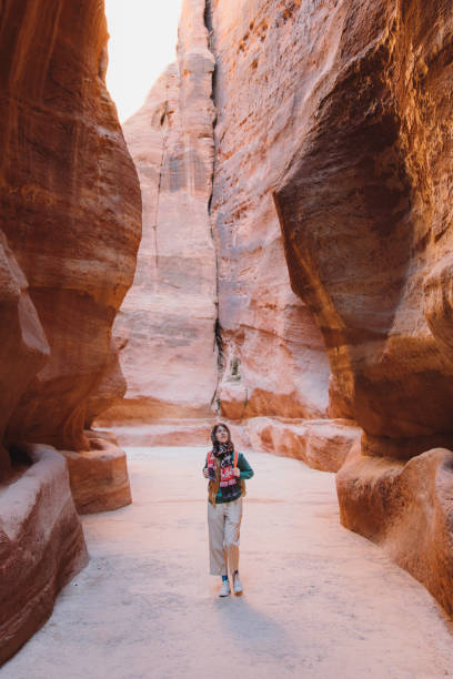 viaggiatrice che esplora l'antico mondo di petra in giordania camminando all'interno del canyon - roccia sedimentaria foto e immagini stock