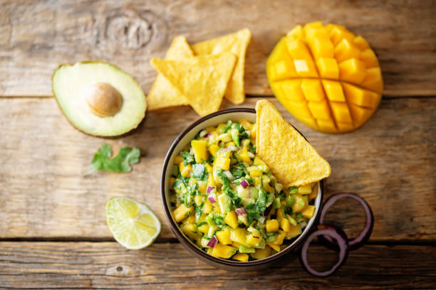 guacamole de mango con chips de maíz e ingredientes para prepararlo - mango salsa fotografías e imágenes de stock