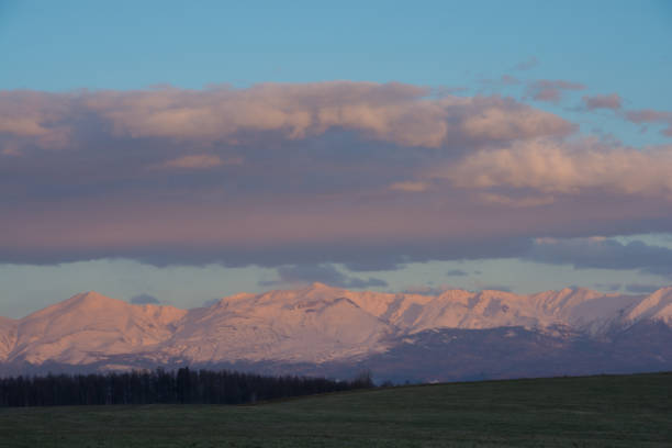 istock Snowy mountains in spring reflecting the setting sun 1362923952