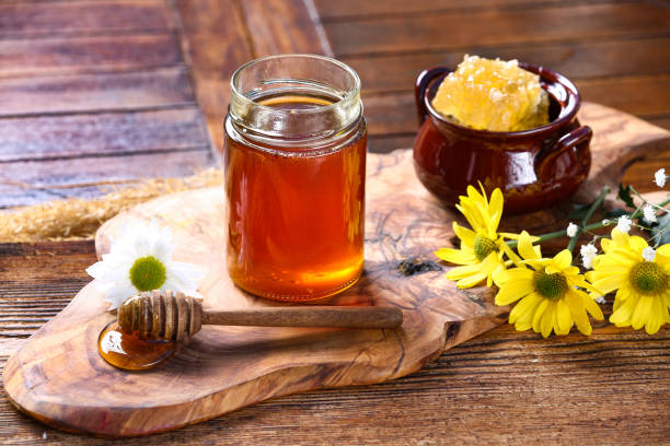 istock Honey jar with on rustic wooden table 1362924590