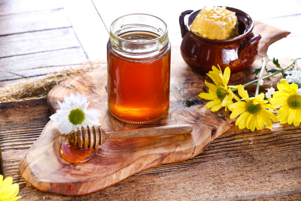 istock Honey jar with on rustic wooden table 1362924651