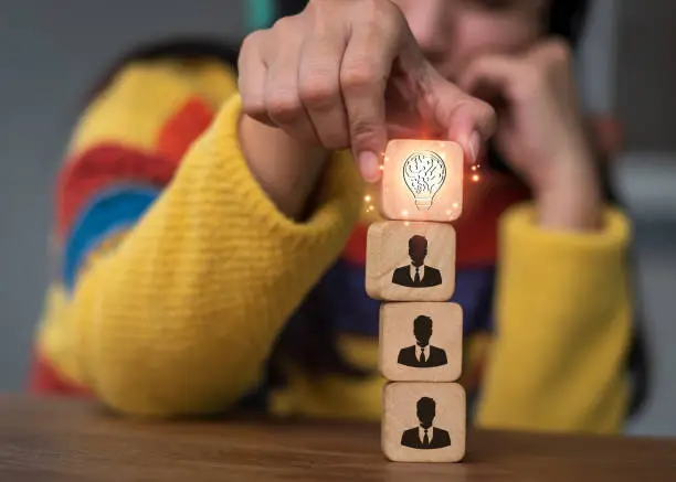 Photo of Hand stacking wood blocks on a table with the symbols Action plan, Goal and target, success and business target concept, project management, and corporate strategy development
