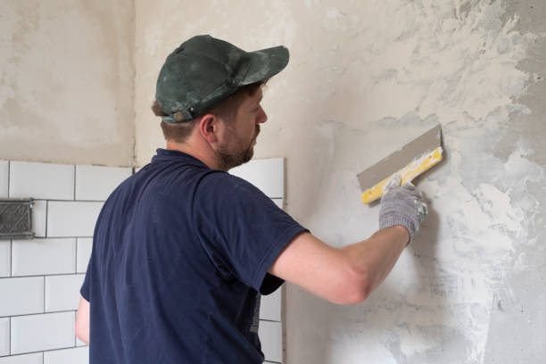 istock Caucasian man put plaster patching up the cracks on the wall. 1362926518