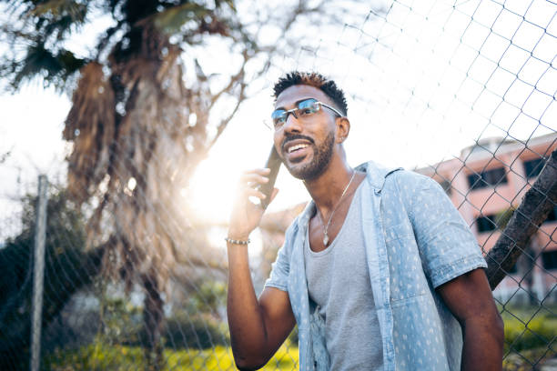 istock Handsome latin american man using his smartphone smiling on the street 1362928273