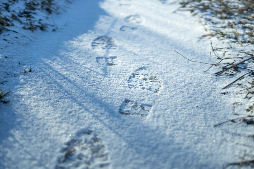 Footprint in the fresh snow, tread in the snow. Texture of snow surface.