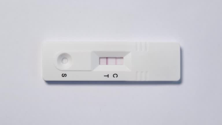 Hand adding sample on a Covid-19 antigen test cassette with a positive result.