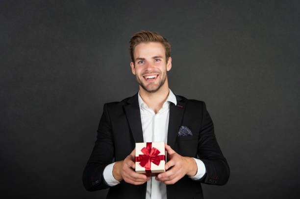istock happy young man in suit with birthday present box 1362930286