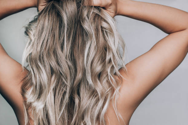 gros plan d’une jeune femme blonde debout avec le dos avec les cheveux ondulés. résultat de la coloration - ringlet photos et images de collection