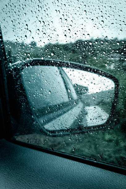 Raindrops on the car's rearview mirror. Summer rain in Colatina, Espírito Santo state, Brazil.