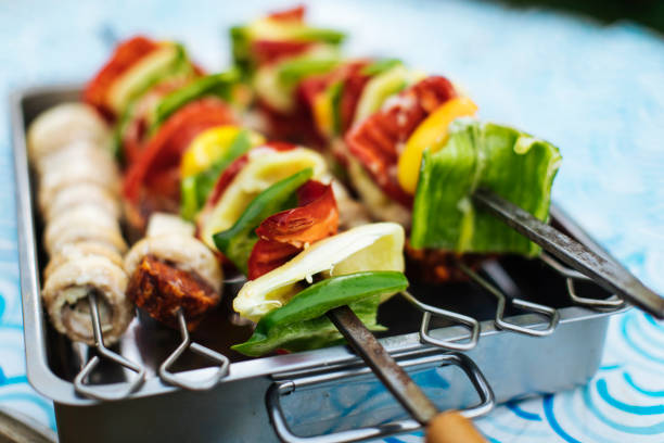 Vegetable skewers preparing on embers on wild camping.Cooking on camping.