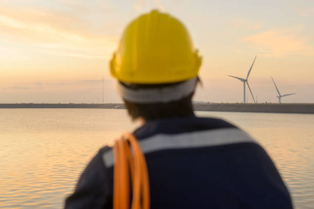 istock A male engineer wearing a protective helmet at sunset , selective focus on background 1362933014