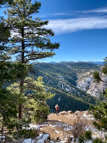 Young woman taking photos of Mount Falcon views in Colorado.