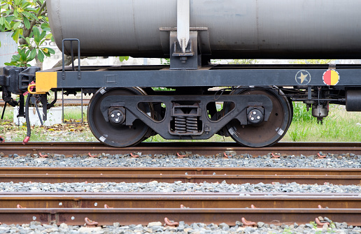 The bogie of the oil tanker in the freight train is parking in the railway yard of the city station, waiting to contain the oil in the oil depot, front view with the copy space.