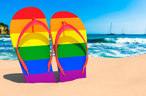 Flip flops with LGBT rainbow flag on the beach. 3D rendering