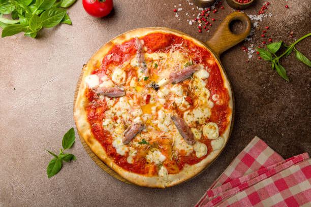 pizza with cheese and anchovies top view on brown concrete table - oregano freshness herb brown imagens e fotografias de stock